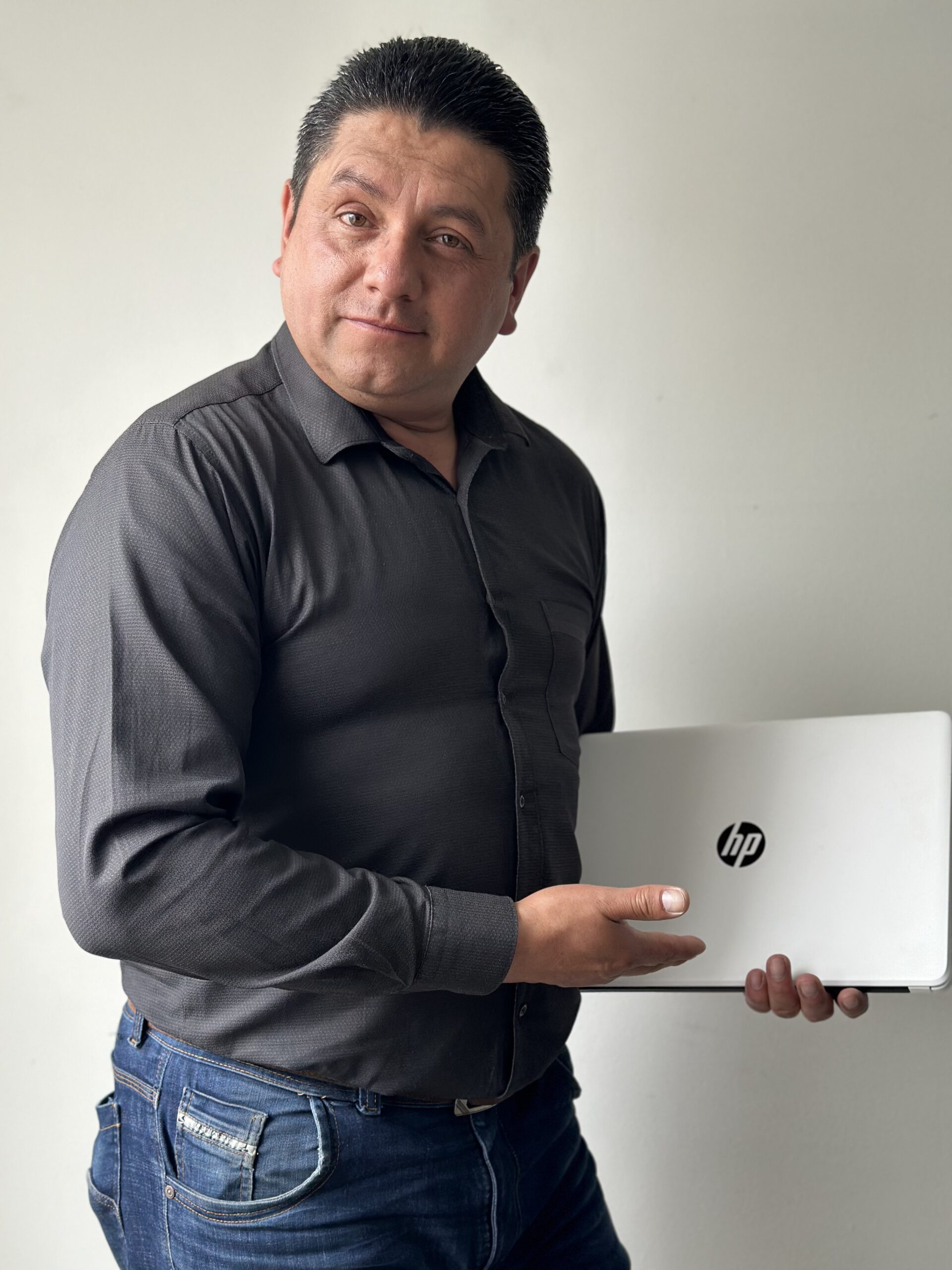 William Martínez, de PC Renova, sostiene un portátil listo para comprar